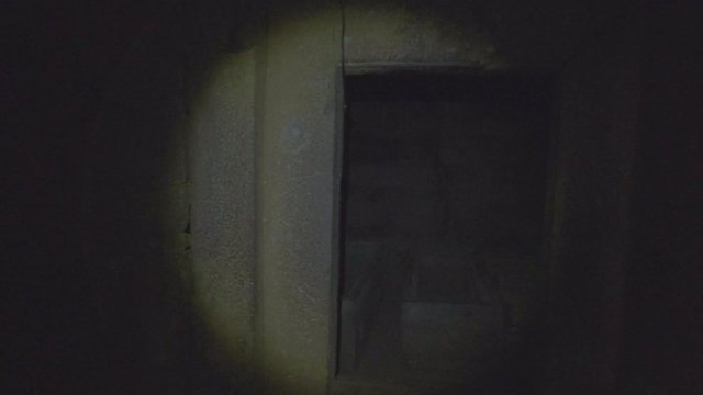 Camera pan right flashlight illuminated underground chambers of the Tomb of King Gebre Meskel to reveal three crypts in Aksum, Ethiopia