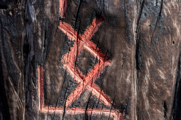 Slavic pagan esoteric symbols (runes) are carved on a wooden surface