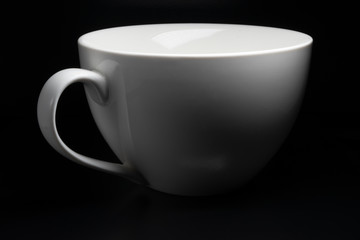 White porcelain cup on black background