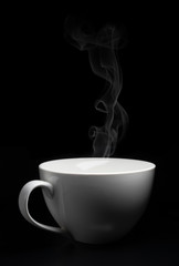 White porcelain cup on black background with steam