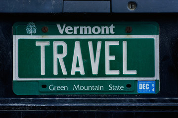 Fototapeta na wymiar This is a vanity license plate that says TRAVEL. It is a green Vermont license plate. Vermont is the Green Mountain State.