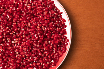 Pomegranate seeds in plate close up 