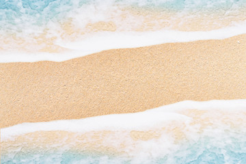Fototapeta na wymiar Top view soft wave and white foam of ocean on sand beach.