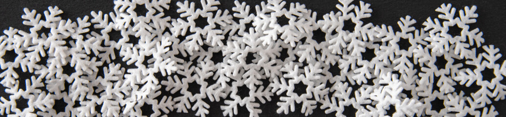 Felt snowflakes in a border on dark gray slate as a background
