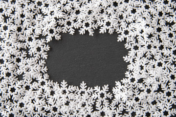 Felt snowflakes on dark gray slate as a background