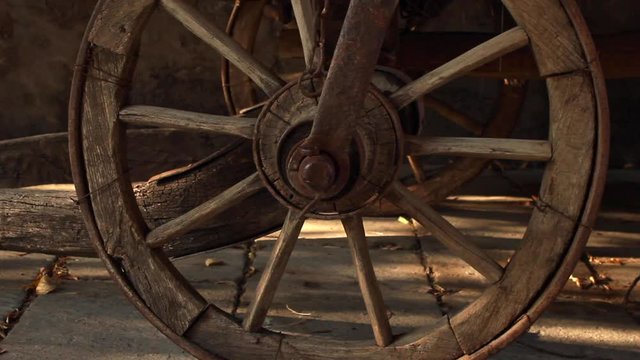 Close up view of wooden cart wheel and spokes. slow pan right