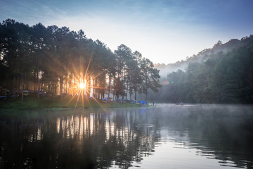 Landscape with the mist in the morning at the lake, sunrise in the mountains landscape. Tourists camping at the lake with foggy in the morning at Pang ung, Mae Hong Son, Thailand.