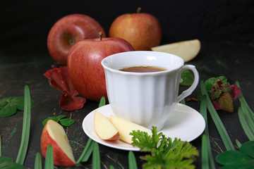 cup of hot apple tea on a dark table