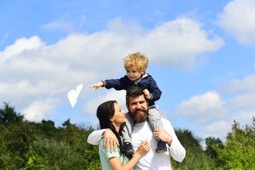 Cute boy with parents playing outdoor. Enjoy. Childhood. Father giving son ride on back and hug wife in park. Generation. Funny time. Carefree. Father and son enjoying outdoor.