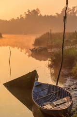 Vietnamese misty river with fishing boats and nets. Hoi An neighborhood, at sunrise.