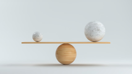 wooden scale balancing a small and a big ball in front white background