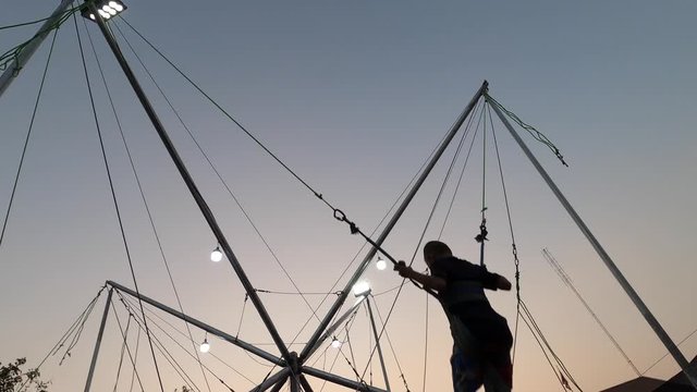 The boys had fun playing Trampoline Bungee at the festival on sunset sky 