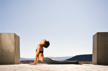 A woman does yoga at a lava field near Amboy Crater 