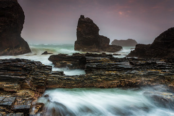 Raging waters over and around jagged craggy coastal rocks