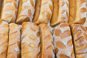 Freshly baked appetizing loaves of bread made from mixed rye and wheat flour with bran in a bakery. Edible background, flat lay