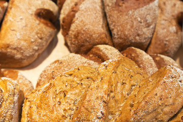 A close-up view on wholesome rye freshly baked bread with flax and sunflower seeds in a bakery. Healthy diet food. Edible background. Shallow depth of field