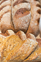 Long loaves from whole grain rye flour with flax and sunflower seeds in a bakery. Healthy diet food. Edible background, flat lay, close-up. Shallow depth of field