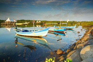 Fototapeta na wymiar Traditional fishing vessels that still use traditional fishing gear, this boat is made of wood that is resistant to sea water. Fishing boats dock at the seashore.