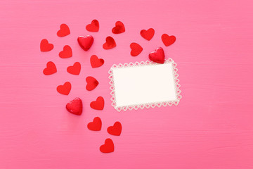 Valentines day concept. red hearts over wooden pink background. Flat lay composition
