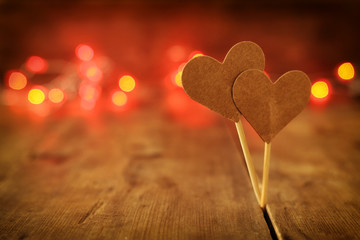 Valentines day concept. two hearts over wooden background and glitter lights