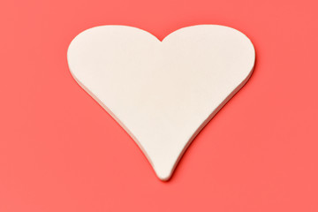 Heart. One  big white wooden heart on a pink background. Valentine's day, February 14.