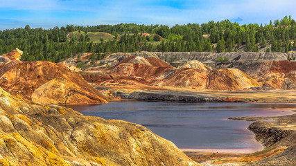 Landscape like a planet Mars surface. Ural refractory clay quarries. Nature of Ural mountains, Russia. Solidified red-brown black Earth surface for screensaver for desktop, banner, cover.