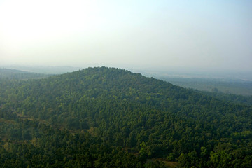 landscape with mountains, forests captured in a beautiful foggy morning.