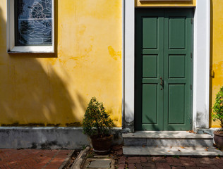 Thai architecture is influenced by Europe,Yellow wall And Green door Unique pattern of Thailand,Texture wall color Stain