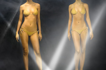 female mannequins in swimsuits in the spotlight. dancing girls on a monochrome background....