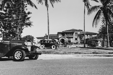 American vintage retro car parked on road on background ancient castle. black and white photo
