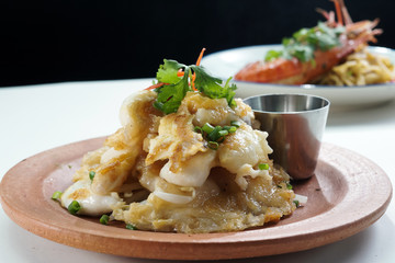 Thai food, fried mussel pancake in hot pan or Oysters