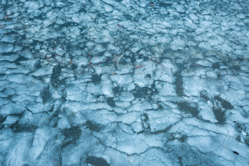 frozen river surface texture with cracked ice and blue tint