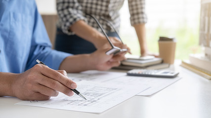 Engineer or architect teamwork working on construction project with building model and blueprint in office. Construction concept.