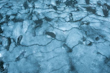 frozen river surface texture with cracked ice and blue tint