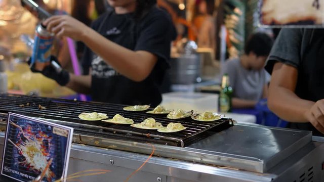Thai chef braise traditional Thai street food, night market Bangkok