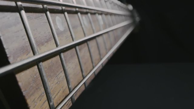 Macro of a bass guitar neck isolated on black background