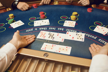 Hands of players and croupiers in the game cards.