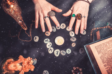 Astrology and esotericism. Female witch hands conjure over the rune circle. On a black background...