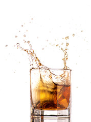 big splash from falling ice in a glass of whiskey on a white background