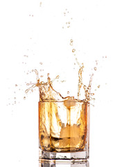big splash from falling ice in a glass of whiskey on a white background