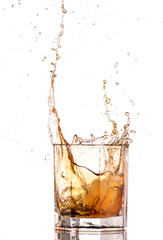 big splash from falling ice in a glass of whiskey on a white background