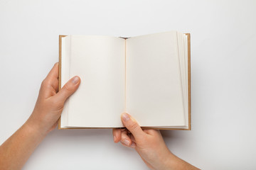 A5 open book mockup with hands. Empty template of page. Blank for design. Isolated on white...