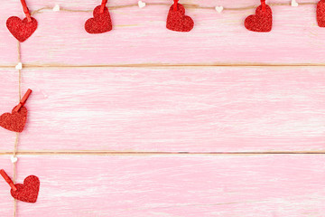 Valentines Day Background with Frame from Jute Rope with Red Glitter Hearts with Pins and Confetti Small Hearts on Pink Wooden Background. Love, Romance, Valentine Day Concept. Copy Space, Top View