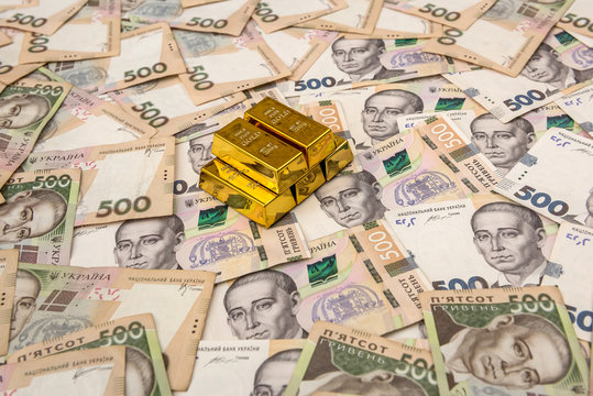 stacks of gold bars on ukraine moneu uah . top view