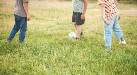 Caucasian boys with a soccer ball on a football field.