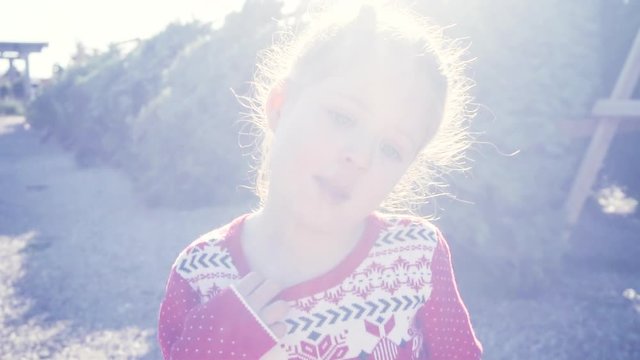 Slow motion. Little girl in red dress on Christmas tree farm.