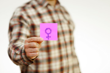 a man holds a sticker with a woman's gender sign. Sex education