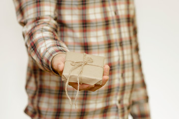 A man holding parcel post gift box on hand. A man gives a box with a gift