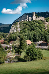 romantic castle on top of a hill in a mountainous valley