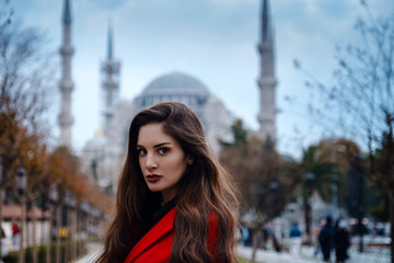 Obraz na płótnie Canvas Latin American woman or Turkish woman in a red stylish coat